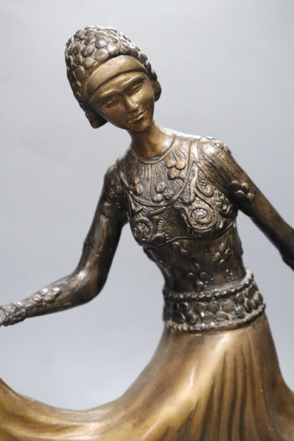 A patinated metal model of a 1930s dancer, on stepped circular base, 48cm